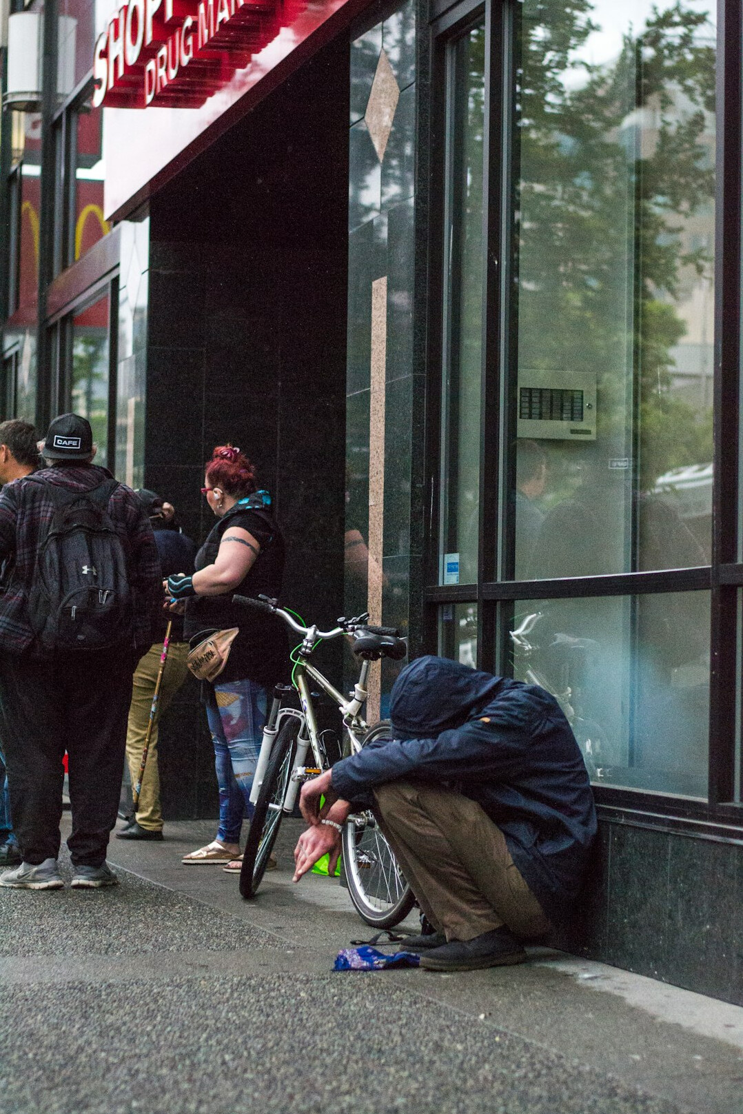 Photojournalist crouched down photographing a street scene with a camera
