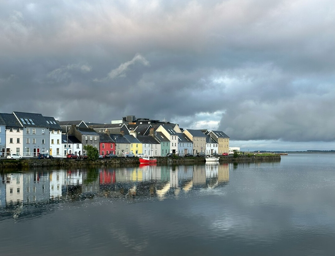 Colorful harbor houses reflected in calm water in a Danish coastal town
