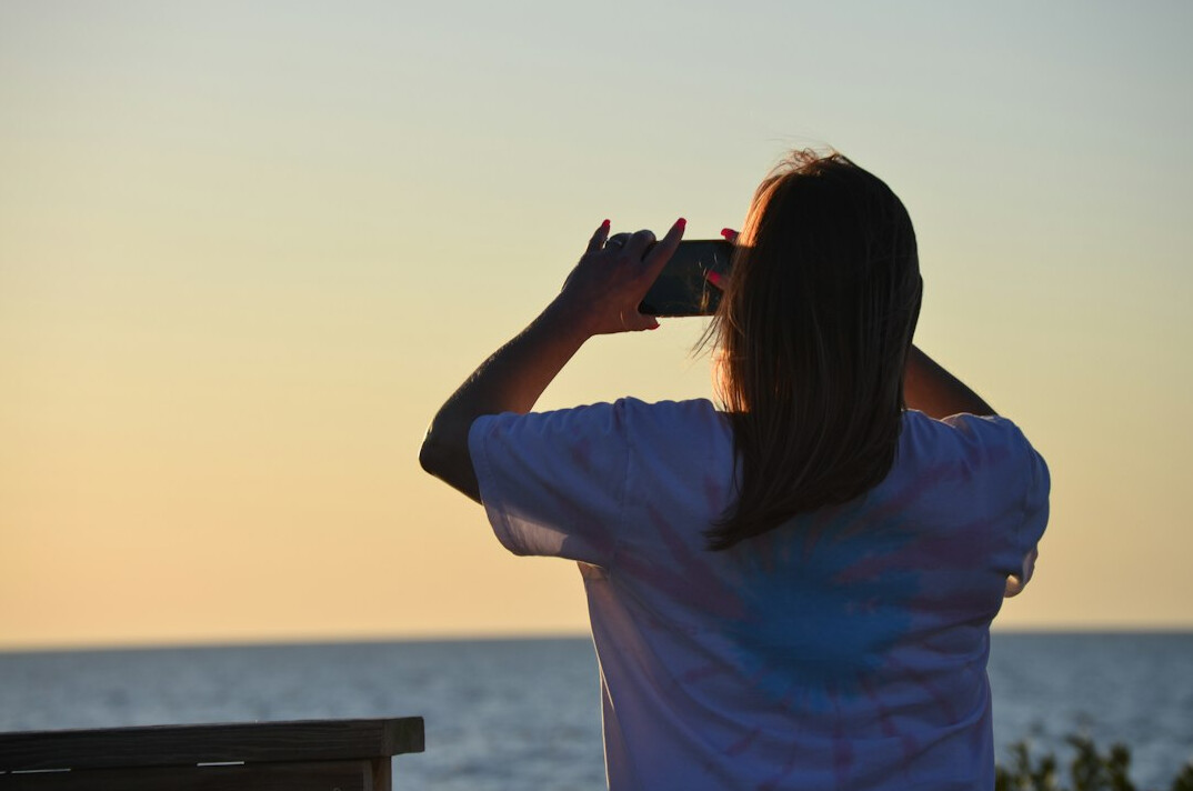 woman taking photos beach